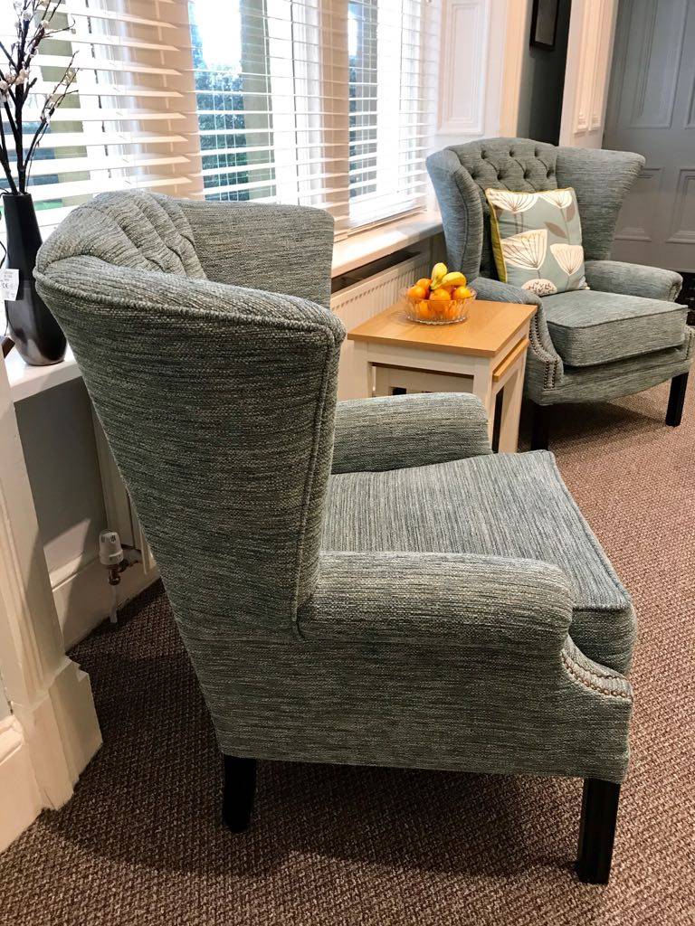 Matching pair of tufted wingback chairs in client living room