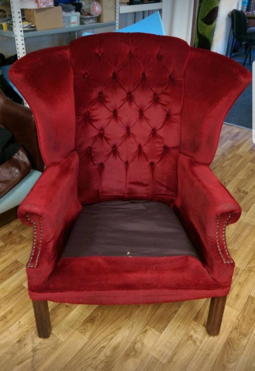 Red velvet button-tufted wingback chair before reupholstery