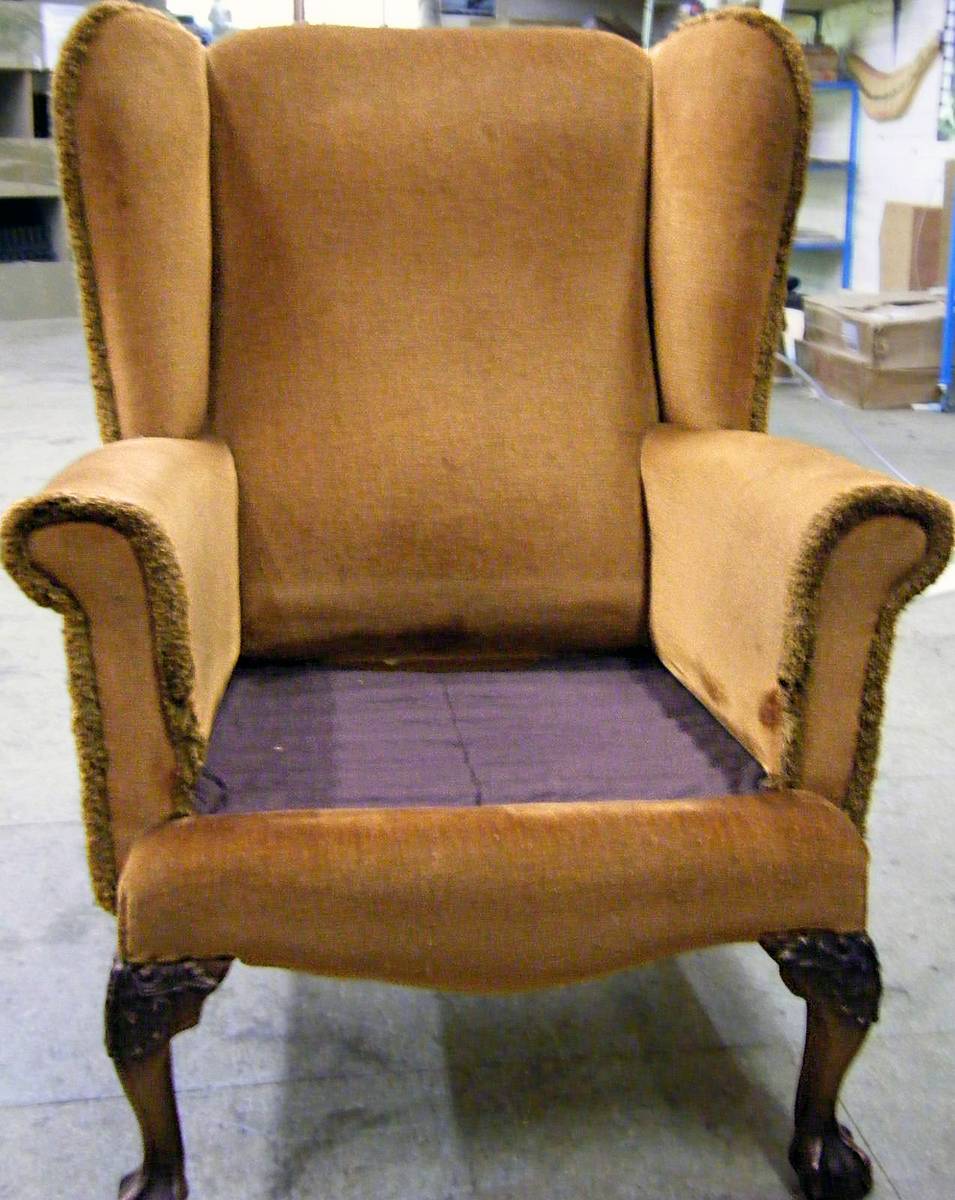 Wingback armchair in worn brown velvet before restoration